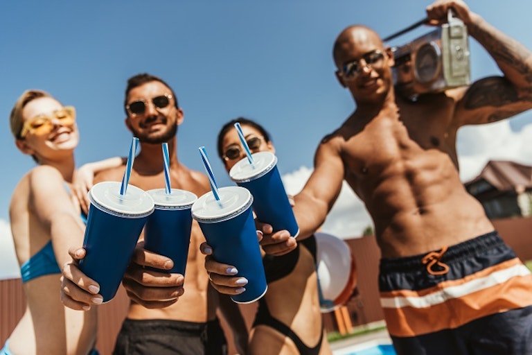 A group of young adults wearing swinsuits and holding plastic cups